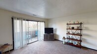 Located at 4284 Hidden Hills Dr in Kalamazoo, Michigan, this single-floor residence offers a well-organized layout designed for comfortable everyday living. The living room is a welcoming, carpeted space bathed in natural light streaming through large sliding glass doors that open onto a private balcony, providing pleasant outdoor views. The room offers generous space for seating and entertainment, with a textured ceiling adding a classic touch. The kitchen is equipped with ample white cabinetry trimmed in dark wood, a double-basin sink with a pass-through window, a dishwasher, an electric range, and a full-size refrigerator, all set atop durable hardwood-style flooring. The bedroom is a comfortable, carpeted retreat featuring a spacious closet with bifold doors and convenient access to an adjacent bathroom. Two bathrooms serve the residence: one featuring a bathtub and shower combination with a vanity and mirror, and a second with hardwood-style flooring and a toilet and vanity. Throughout the home, neutral wall tones and consistent flooring choices create a cohesive, understated ambiance that is both practical and inviting.