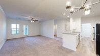 Located at 4343 Warm Springs Rd in Columbus, Georgia, this single-story 2-bedroom, 2-bathroom home offers a thoughtfully designed open-concept layout ideal for comfortable everyday living. The combined kitchen and living room serves as the heart of the home, where a peninsula with granite countertops and a built-in sink connects the kitchen to the carpeted living area. The kitchen is equipped with white cabinetry, black appliances including a refrigerator, microwave, and range, and is illuminated by a skylight panel and recessed lighting. The living room features a ceiling fan and access to a private exterior door. The generously sized primary bedroom includes a ceiling fan, plush carpet, and direct access to an en-suite bathroom and a spacious walk-in closet with wire shelving systems. The second bedroom also features carpet, a ceiling fan, crown molding, and a window overlooking the outdoors. Both bathrooms are finished with granite-topped white vanities and wood-look vinyl flooring; one includes a full bathtub. Additional highlights include two well-organized closets with wire shelving, a dedicated laundry area, and wood-look flooring in the entry and wet areas. The clean, neutral palette throughout creates a bright and inviting ambiance.