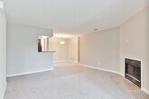 This single-floor residence in Union City, GA presents a well-organized layout with distinct living, dining, kitchen, and sleeping areas connected by an open, flowing floor plan. The living room serves as a central gathering space, highlighted by a fireplace framed by neutral-toned walls and plush carpeting. Natural light enters through multiple windows fitted with blinds, and a sliding glass door provides direct access to an outdoor area, bringing in views of surrounding greenery.

The kitchen is outfitted with rich, dark wood cabinetry, granite-patterned countertops, a stainless steel sink, and a dishwasher. A peninsula-style counter separates the kitchen from the adjoining living and dining spaces, creating an open and connected feel. Wood-look flooring extends through the kitchen and bathrooms, providing a practical contrast to the carpeted living and sleeping areas.

The bedrooms are carpeted and receive natural light through windows, offering a calm and neutral atmosphere. The bathrooms feature dark wood vanities topped with granite-style counters, undermount sinks, large mirrors, and tub-shower combinations, all set on wood-look flooring. The overall design is cohesive, with warm neutral tones and functional finishes carried consistently throughout the home.