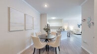 Located at 4001 N Taggart Cay in Sarasota, FL, this well-appointed 2-bedroom, 2-bathroom single-story residence offers a thoughtfully designed open-concept floor plan. The combined living, dining, and kitchen area forms the heart of the home, featuring light wood-style flooring, crown molding, and an abundance of natural light from large windows. The kitchen is outfitted with granite countertops, white cabinetry, stainless steel appliances, and a peninsula with bar seating — ideal for casual dining or entertaining. The adjacent dining area comfortably accommodates a four-seat table, while the spacious living room provides a relaxed atmosphere with generous wall space. The primary bedroom offers plush carpeting, a ceiling fan, and a well-sized closet, while the second bedroom mirrors these features with added outdoor views through large windows. Both bathrooms are finished with granite vanity countertops, white cabinetry, wood-style tile flooring, and tub-shower combinations. Additional highlights include four closets for ample storage, a dedicated laundry area, and a versatile unclassified room suitable as a home office or flex space. The home's consistent neutral palette and quality finishes create a clean, modern ambiance throughout.