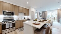 Located in Flemington, NJ, this well-appointed two-bedroom, two-bathroom residence offers a thoughtfully designed single-floor layout with modern finishes throughout. The open-concept kitchen and living area serves as the heart of the home, featuring flat-front wood-toned cabinetry, a classic white subway tile backsplash, stainless steel appliances including a gas range, microwave, dishwasher, and French door refrigerator. A large white-quartz kitchen island provides additional seating and workspace, flowing seamlessly into the living room. The living area is bright and welcoming, with large sliding glass doors that open to a private balcony overlooking a landscaped courtyard. Light wood-tone flooring runs throughout the main living spaces. The primary bedroom is a comfortable retreat with a warm, neutral color palette and access to a dedicated walk-in closet featuring built-in shelving. The second bedroom offers its own distinct character with a bold accent wall. Both bathrooms are finished in a clean, contemporary style, with the full bath showcasing a glass-enclosed walk-in shower and a wood-vanity with an undermount sink. Two closets and a hallway complete the efficient and functional layout of this modern residence.