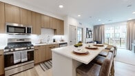 Located in Flemington, NJ, this well-appointed two-bedroom, two-bathroom residence offers a thoughtfully designed single-floor layout with modern finishes throughout. The open-concept kitchen and living area serves as the heart of the home, featuring flat-front wood-toned cabinetry, a classic white subway tile backsplash, stainless steel appliances including a gas range, microwave, dishwasher, and French door refrigerator. A large white-quartz kitchen island provides additional seating and workspace, flowing seamlessly into the living room. The living area is bright and welcoming, with large sliding glass doors that open to a private balcony overlooking a landscaped courtyard. Light wood-tone flooring runs throughout the main living spaces. The primary bedroom is a comfortable retreat with a warm, neutral color palette and access to a dedicated walk-in closet featuring built-in shelving. The second bedroom offers its own distinct character with a bold accent wall. Both bathrooms are finished in a clean, contemporary style, with the full bath showcasing a glass-enclosed walk-in shower and a wood-vanity with an undermount sink. Two closets and a hallway complete the efficient and functional layout of this modern residence.