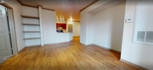 This 880 square foot apartment offers a thoughtful blend of comfort and functionality. The open-concept design seamlessly integrates the living room and kitchen, creating a spacious feel. The kitchen boasts rich wood cabinetry, complemented by stainless steel appliances and a practical breakfast bar.

Hardwood flooring runs throughout the main living areas, adding warmth and elegance. The primary bedroom, measuring 190 square feet, provides ample space and includes a ceiling fan for added comfort. Both bedrooms feature plush carpeting and generous closet space with wire shelving systems.

The bathroom showcases a modern aesthetic with a tiled shower surround and a decorative checkered tile accent. Large windows in the living area and bedrooms allow for abundant natural light, while plantation shutters offer privacy control.

Additional amenities include a full-sized washer and dryer housed behind louvered doors, recessed lighting, and a ceiling fan in the living room. The apartment's efficient layout maximizes the use of space, making it an ideal choice for those seeking a contemporary living environment in a compact footprint.