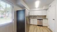 Located at 2637 Sawbury Blvd in Columbus, Ohio, this two-story home offers a well-organized layout across two levels connected by a central staircase. The main level showcases a bright, updated kitchen equipped with white shaker-style cabinetry, granite countertops, a subway tile backsplash, and stainless steel appliances including a refrigerator and dishwasher. Light wood-style vinyl plank flooring runs throughout the main level, complementing the clean, neutral color palette. The living area features a large bay window that invites an abundance of natural light and provides views of the surrounding greenery, further enhancing the open and airy atmosphere. Textured ceilings are present throughout the home. The upper level houses multiple carpeted bedrooms, each with windows that allow natural light to filter in. The bathroom is finished with classic white subway tile surrounding a full tub-shower combination, a white vanity, and wood-style flooring. An additional room on the lower level features rich wood-tone vinyl plank flooring and direct access to other areas of the home. Throughout both floors, the home maintains a consistent, clean aesthetic with bright white walls, neutral tones, and practical finishes that create a welcoming and functional living environment.