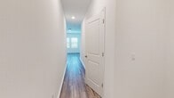 Located at 38389 Honey Suckle Dr in Dade City, Florida, this two-story home presents a clean, modern aesthetic throughout its thoughtfully designed layout. The interior is finished with a consistent palette of crisp white walls and warm wood-look luxury vinyl plank flooring that runs through the main living areas, creating a bright and cohesive feel from room to room.

The kitchen serves as a standout feature, showcasing white shaker-style cabinetry, granite countertops with subtle veining, and a central island equipped with a double-basin sink. Stainless steel appliances, including a range, over-the-range microwave, refrigerator, and dishwasher, complete the functional and polished space. Recessed lighting overhead enhances the open, airy atmosphere.

Bedrooms are carpeted for comfort and feature ample natural light from windows dressed with blinds. Several bedrooms include walk-in closets with built-in shelving for organized storage. The hallways are clean and well-lit, connecting spaces efficiently across both floors.

Bathrooms are finished with wood-look tile flooring, white vanities with solid countertops, and chrome fixtures. One bathroom features a tub-shower combination, while another offers a glass-enclosed walk-in shower, providing functional variety throughout the home.