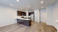 Located at 7619 W King Top Rd in Magna, Utah, this three-floor home offers 3 bedrooms, 4 bathrooms, and a well-organized layout designed for comfortable living. The entry level provides a welcoming entrance and staircase access to the floors above. The main living floor features an open-concept space combining the kitchen, dining, and living areas. The kitchen is appointed with rich dark-stained cabinetry, white quartz-style countertops, a peninsula with an undermount sink, and a full suite of stainless steel appliances including a refrigerator, range, and microwave. Wood-look flooring runs throughout this level, enhancing the clean, modern aesthetic. The upper floor hosts all three bedrooms, including a generously sized primary bedroom with its own en-suite bathroom and a spacious walk-in closet featuring wire shelving on three sides. The additional bedrooms are carpeted, bright, and well-proportioned, each with window blinds providing natural light. The bathrooms are consistently finished with dark vanity cabinetry, white countertops, brushed nickel hardware, and light tile flooring. Additional highlights include five closets total, a dedicated laundry area, a utility room, and three staircases connecting the multi-level layout.