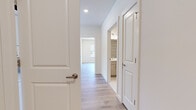 This well-appointed 2-bedroom, 2-bathroom home in Scotch Plains, NJ offers a thoughtfully designed single-floor layout with modern finishes throughout. Light hardwood-style flooring flows seamlessly across the entire space, creating a bright and cohesive aesthetic.

The open-concept kitchen and living area serves as the heart of the home. The kitchen features white shaker-style cabinetry, a classic subway tile backsplash, dark quartz countertops, and a large central island with seating potential. Stainless steel appliances — including a gas range, microwave, and French door refrigerator — provide functionality, while two elegant gold-accented pendant lights add a stylish touch. A sliding glass door opens to a private balcony, filling the space with natural light.

The spacious living room is lined with multiple large windows offering lush outdoor views, allowing abundant natural light to brighten the area throughout the day.

The generously sized primary bedroom includes a walk-in closet with built-in wire shelving systems. Both bathrooms are finished with neutral large-format tile flooring, modern wood-toned vanities, and glass-enclosed walk-in showers. The central hallway connects all rooms efficiently, with a dedicated closet providing additional storage. Recessed lighting throughout enhances the clean, contemporary feel of this move-in-ready home.