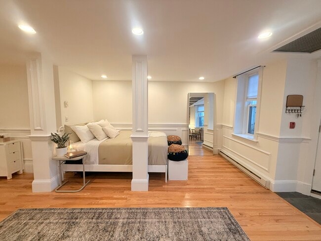 living space - view of queen bed from side - 382 Riverway St