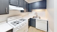 Located in Indianapolis, IN, this two-floor home at 8329 Zona Dr offers a practical and well-organized layout across its two levels. The kitchen serves as a functional centerpiece, featuring navy blue upper and lower cabinetry accented with brushed nickel hardware, white light-colored countertops, and a classic white tile backsplash. A gas range, built-in dishwasher, and stainless steel sink contribute to a fully equipped cooking space, while light wood-look flooring ties the area together with a clean, modern feel.

The living areas and bedrooms reflect a neutral, move-in-ready aesthetic. Several rooms feature warm-toned carpeting paired with soft greige walls and white baseboards, creating a cohesive and understated palette. Select rooms are finished with light wood-look flooring, adding visual variety throughout the home. Multiple bedrooms include windows fitted with horizontal blinds, allowing for natural light and outside views. Closet space is present, with at least one walk-in closet offering a full hanging rod and shelving.

The bathroom includes a full-size soaking tub with a shower overhead, surrounded by clean white tile and complemented by chrome fixtures. The overall ambiance of the home is tidy and straightforward, suitable for comfortable everyday living.