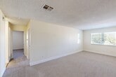 Located at 6001 Auburn St in Bakersfield, CA, this single-story, 2-bedroom, 2-bathroom home offers a practical and well-organized layout. The interior features a neutral color palette with cream-toned walls, textured ceilings, and soft carpet throughout the living and bedroom areas, while light ceramic tile flooring runs through the kitchen and bathrooms.

The kitchen is equipped with warm oak cabinetry, granite-patterned countertops, a white electric range, dishwasher, and refrigerator, complemented by a window that allows natural light to brighten the space. The kitchen flows directly into the adjacent dining area, creating a convenient combined living and eating space.

The spacious primary bedroom features plush carpeting, a window with views of the surrounding greenery, and direct access to the hallway. The second bedroom also includes carpeted floors, a closet, and a window with natural light. Both bedrooms are served by two full bathrooms, each appointed with tile flooring, granite-patterned countertops, white cabinetry, and a bathtub/shower combination.

Additional highlights include a dedicated laundry area, two closets for ample storage, and a central hallway connecting all rooms. The home's efficient single-floor layout ensures seamless accessibility throughout.