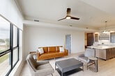 Located at 3100 Lake Villa Dr in Metairie, Louisiana, this well-appointed 2-bedroom, 2-bathroom residence offers a thoughtfully designed single-floor layout. The open-concept living, dining, and kitchen area serves as the heart of the home, bathed in natural light and finished with light hardwood-style flooring throughout. The contemporary kitchen is a standout feature, showcasing two-tone cabinetry in charcoal and warm wood tones accented with brushed gold hardware, a large waterfall quartz island with bar seating, stainless steel appliances, and a sculptural globe pendant light. A built-in desk nook provides a dedicated workspace within the kitchen zone. The living area is generously proportioned, complete with a ceiling fan and easy access to a private balcony that offers open views of the Metairie skyline and surrounding neighborhood. Both bedrooms are bright and tranquil, with large windows, ceiling fans, and ample closet space. The primary bedroom features direct access to its own bathroom. The bathrooms are elegantly finished with marble-look tile flooring, wood-toned vanities, white quartz countertops, and tiled tub-shower combinations. An in-unit laundry area with a full-size washer and dryer adds everyday convenience to this modern residence.