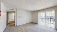 Located at 12000 Fleming Dr in Houston, TX, this 2-bedroom, 2-bathroom residence offers a practical and well-organized single-floor layout. The living room features plush carpeting, a textured ceiling, a white brick accent wall, and a sliding glass door with vertical blinds that opens to a private patio, allowing natural light to fill the space. A pass-through window connects the living and dining areas to the kitchen, creating an open, communicative flow between spaces. The kitchen is equipped with a built-in range and overhead cabinetry. The dining room sits adjacent, providing a defined area for meals. Both bedrooms are carpeted and generously proportioned, with the primary bedroom featuring a ceiling fan with light fixture and a window with outdoor views. Each bedroom is supported by its own closet, and the unit includes a total of four closets — some walk-in style with wire shelving systems — offering exceptional storage. One utility closet features washer/dryer hookups. Both bathrooms include a tub-shower combo with tiled surrounds and light wood-look flooring. A central hallway connects the living areas to the private quarters, completing this efficiently designed home.