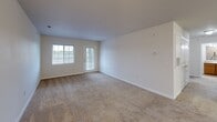 Located at 4020 Eight Belles Ln in Greensboro, NC, this single-floor, 2-bedroom, 2-bathroom home offers a practical and comfortable layout with neutral finishes throughout. The open kitchen and living area serves as the heart of the home, featuring tile flooring, warm wood cabinetry, dark laminate countertops, a center island with additional counter space, and black appliances including a range, microwave, dishwasher, and refrigerator. The living room is carpeted and filled with natural light, thanks to large windows and a glass exterior door that leads outside. Both bedrooms are carpeted and well-lit, with the primary bedroom offering a generous footprint, a ceiling fan, and a window overlooking the surrounding neighborhood. Each bedroom is served by its own closet, including a spacious walk-in closet with wire shelving for organized storage. The two bathrooms are clean and functional, each featuring a tub-shower combination with tile surround. One bathroom includes a wood-tone vanity with a granite-style countertop. Crisp white walls and neutral tones carry throughout the home, creating a bright and cohesive atmosphere suited for a variety of living arrangements.