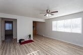 Located at 525 S Curtis Rd in Boise, Idaho, this 1-bedroom, 1-bathroom unit is designed with a clean, functional layout across a single floor. Light wood-style flooring runs throughout the entire space, creating a cohesive and bright aesthetic. The spacious living area features a ceiling fan with an integrated light fixture, baseboard heating, and a wall-mounted AC unit, ensuring year-round comfort. Natural light streams in through slatted blinds, enhancing the open feel of the room. The kitchen is positioned adjacent to the living area and features a peninsula with warm wood cabinetry, white countertops, and a full suite of stainless steel appliances including a refrigerator, electric range, over-the-range microwave, and a stainless sink. The bedroom offers a comfortable layout with a wide closet, a natural light window, and continued wood flooring. The full bathroom includes a white vanity with ample cabinet storage, a large mirror, and a tub-shower combination. Overall, the unit presents a clean, updated interior with a practical and inviting atmosphere well-suited for everyday living in the heart of Boise.