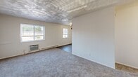 Located at 932 Lincoln St in Portsmouth, Virginia, this 2-bedroom, 1-bathroom residence offers a practical and functional single-floor layout. The living room is a welcoming space featuring plush carpet, a textured ceiling, baseboard heating, and dual windows that invite natural light and outdoor views. The combined dining room and kitchen area provides a convenient, open flow for everyday living. Both bedrooms are carpeted and include ceiling fans, windows with blinds for natural light and privacy, and baseboard heating. The primary bedroom offers a comfortable footprint, while the second bedroom is equally well-proportioned. A hallway connects the rooms efficiently, and the unit is notably well-equipped with five closets, ensuring generous storage throughout. The full bathroom features a clean, white tub-shower combo and wood-look vinyl flooring, offering a crisp and functional design. White walls and neutral tones are carried consistently throughout the residence, contributing to a bright, clean aesthetic. The unit also includes an in-wall air conditioning unit in the living area for added climate control comfort.