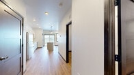Located at 2090 Carlson Dr in North Mankato, MN, this thoughtfully designed one-bedroom, one-bathroom residence offers a clean, modern aesthetic throughout its single floor of living space. The open-concept kitchen and living area serves as the heart of the home, featuring warm luxury vinyl plank flooring, recessed lighting, and large black-framed windows with a sliding glass door that invite abundant natural light and views of the surrounding greenery. The kitchen is well-appointed with white shaker-style cabinetry, white countertops, a central island with pendant lighting overhead, and a full suite of stainless steel appliances including a range, over-the-range microwave, refrigerator, and dishwasher. The bedroom is a comfortable, quiet retreat with its own windows and the same consistent flooring found throughout the unit. A dedicated walk-in closet provides ample storage, outfitted with wire shelving systems. The bathroom offers a clean, contemporary finish with a grey vanity, white countertop, wood-look flooring, and matte black hardware and fixtures. Neutral tones and clean lines throughout create a bright, cohesive living environment well-suited for everyday comfort.
