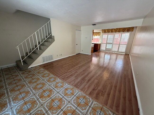 Bright, open living and dining space with large windows and plantation shutters. - 1134 W Huntington Dr