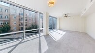 Located in the heart of uptown Charlotte, this 2-bedroom, 3-bathroom residence offers an expansive, single-floor layout with generous living space throughout. The open-concept living and kitchen area is a standout, featuring large-format polished marble-style tile flooring that reflects abundant natural light pouring in through floor-to-ceiling glass windows and sliding doors. The kitchen is equipped with rich cherry wood cabinetry, granite countertops, a built-in kitchen island, and a stainless steel built-in refrigerator. A private balcony accessible from the main living area provides direct views of the Charlotte skyline and surrounding urban greenery. The spacious primary bedroom is carpeted and filled with natural light from large windows overlooking the city, complemented by a generous walk-in closet with wire shelving throughout. The second bedroom, also carpeted and featuring a ceiling fan, offers comfortable proportions and city views. All three bathrooms are finished with tile flooring, cherry wood vanities, and granite or dark stone countertops, with at least two featuring glass-enclosed walk-in showers. Additional features include a dedicated laundry area, multiple closets, and welcoming hallways connecting each zone of the residence seamlessly.