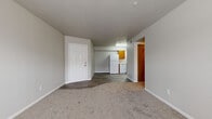 Located at 9680 Lexington Ave in De Soto, Kansas, this two-bedroom, two-bathroom single-floor residence offers a practical and well-organized layout. The living area features neutral-toned carpet and a large window that brings in natural light, creating a bright and open feel. A smooth transition connects the carpeted living space to the kitchen, which features wood-look vinyl flooring, warm oak-toned cabinetry, light countertops, and white appliances including a refrigerator, electric range, and dishwasher — providing ample functionality for everyday cooking. The primary bedroom is a generously sized, carpeted retreat with a closet and direct access to a full bathroom. The second bedroom also features carpet, a sliding wood-panel closet door, and a window overlooking the outdoors. Both bathrooms are equipped with a tub-shower combination; one features a wood-toned vanity with a single sink and mirror. A hallway connects the rooms efficiently, and two closets provide added storage throughout the home. Neutral wall tones and consistent finishes across the space lend a clean, cohesive appearance throughout this well-appointed De Soto residence.