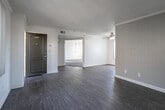 Located near the Pacific Electric Trail in Upland, California, this single-story unit offers a well-organized layout with a bright, neutral color palette throughout. Light wood-style flooring runs through the main living areas, complemented by white baseboards and crown molding details that add a clean, finished look.

The living area is spacious and airy, featuring a ceiling fan, a textured ceiling, and a window that allows natural light to fill the room. A sliding glass door in one section of the living space opens to a private balcony, offering outdoor views and additional light. The entry area provides direct access to a bathroom and includes a closet for added storage.

The U-shaped kitchen is well-equipped with white cabinetry, dark countertops, a gas range, and a window above the sink that brings in natural light. Ample cabinet and counter space makes the kitchen highly functional.

The bedroom features plush carpeting, a walk-in closet with built-in shelving, and a window with a window treatment. An adjoining bathroom is accessible directly from the bedroom. The bathroom includes a clean, white tub-shower combination. The overall ambiance of the space is bright, clean, and move-in ready.