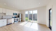 Located at 2134 Fifth Ave in Troy, NY, this efficiently designed studio offers a bright and modern living experience on a single floor. The open-concept kitchen and living area is finished with light hardwood flooring that runs throughout, creating a clean and cohesive aesthetic. Recessed lighting and large floor-to-ceiling windows and a sliding glass door flood the space with natural light while framing views of the surrounding Troy streetscape and greenery. A wall-mounted mini-split unit provides climate control, adding to the space's modern conveniences.

The kitchen is well-appointed with white shaker-style cabinetry extending to the ceiling, a classic subway tile backsplash, and a full suite of stainless steel appliances including a range, microwave, dishwasher, and refrigerator. A second glass-paned exterior door provides an additional access point and further enhances airflow and natural light.

The bathroom is finished with large-format neutral tile flooring and features a sleek vanity with a shaker-style cabinet, a framed mirror, and contemporary fixtures. The crisp white walls throughout the entire unit contribute to a fresh, contemporary ambiance. This thoughtfully designed space offers a compact yet functional layout suited for modern urban living in Troy, NY.