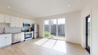 Located at 2134 Fifth Ave in Troy, NY, this efficiently designed studio offers a bright and modern living experience on a single floor. The open-concept kitchen and living area is finished with light hardwood flooring that runs throughout, creating a clean and cohesive aesthetic. Recessed lighting and large floor-to-ceiling windows and a sliding glass door flood the space with natural light while framing views of the surrounding Troy streetscape and greenery. A wall-mounted mini-split unit provides climate control, adding to the space's modern conveniences.

The kitchen is well-appointed with white shaker-style cabinetry extending to the ceiling, a classic subway tile backsplash, and a full suite of stainless steel appliances including a range, microwave, dishwasher, and refrigerator. A second glass-paned exterior door provides an additional access point and further enhances airflow and natural light.

The bathroom is finished with large-format neutral tile flooring and features a sleek vanity with a shaker-style cabinet, a framed mirror, and contemporary fixtures. The crisp white walls throughout the entire unit contribute to a fresh, contemporary ambiance. This thoughtfully designed space offers a compact yet functional layout suited for modern urban living in Troy, NY.