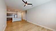 This single-story, 2-bedroom, 2-bathroom residence in Baton Rouge, Louisiana offers a thoughtfully designed open-concept layout with modern finishes throughout. Light wood-style flooring flows through the main living areas, complemented by neutral gray walls and clean white trim that create a bright, contemporary aesthetic.

The living room is generously proportioned and equipped with a ceiling fan, offering natural light through large windows with blinds. It connects seamlessly to the kitchen, which serves as a standout feature of the home. The kitchen showcases gray shaker-style cabinetry reaching to the ceiling, a white subway tile backsplash, stainless steel appliances including a refrigerator, range, and microwave, and a central island with a granite countertop, undermount sink, and pendant lighting above.

Both bedrooms are carpeted and include ceiling fans, natural light from windows, and dedicated closets outfitted with wire shelving systems for organized storage. The bathrooms feature granite-topped vanities with gray cabinetry, wood-look tile flooring, and tub-shower combinations. A hallway connects the bedrooms and bathrooms, providing a functional and private layout overall.