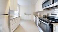 Located at 15 Brookbanks Dr in Toronto's M3A neighbourhood, this 2-bedroom, 1-bathroom unit offers a well-organized layout across a single floor. Warm parquet flooring flows throughout the living areas and bedrooms, lending a classic character to the space. The open living room is generously proportioned, filled with natural light, and connects seamlessly to the kitchen and hallways.

The kitchen is finished with crisp white cabinetry, light countertops, a subway tile backsplash, and a full suite of stainless steel appliances including a refrigerator, stove, oven, dishwasher, and built-in microwave. A window above the counter brings in additional natural light.

The primary bedroom is a comfortable size, featuring large floor-to-ceiling windows that frame sweeping views of the Toronto skyline and surrounding treetops, along with a built-in closet with shelving. The second bedroom also features parquet flooring and ample wall space.

The bathroom is well-appointed with a wide double-sink vanity, white shaker-style cabinetry, a large mirror, and neutral toned finishes throughout.

A standout feature of this unit is the balcony, enclosed by glass railings, which offers expansive elevated views of the city and snow-covered treetops — an ideal setting to enjoy the Toronto skyline year-round.