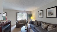 Located at 4121 Kimberly Parkway N in Columbus, Ohio, this single-floor residence offers a well-organized layout designed for comfortable everyday living. The living room serves as the heart of the home, featuring soft carpeted flooring, a textured ceiling, and a large bay-style window dressed with draped curtains that invite generous natural light and outdoor views. A sliding glass door further extends the connection to the outside. The adjacent dining area is a defined space with its own window, seamlessly connected to the galley-style kitchen through an arched opening. The kitchen is efficiently laid out with cream cabinetry lining both walls, a full suite of appliances including a refrigerator, range, and dishwasher, a double sink, and tile flooring. The bedroom is a comfortable, carpeted retreat with a textured ceiling, windows that allow natural light, and ample wall space. The full bathroom features a wide vanity with an integrated sink, a large mirror, and a shower-tub combination. Throughout the home, neutral tones and consistent carpeting in the main living areas create a cohesive and calm ambiance, while the practical single-floor layout ensures easy accessibility and flow between all rooms.