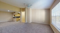 This single-floor residence offers a thoughtfully designed layout that balances comfort and functionality. The open-concept living area is finished with neutral-toned carpet and warm beige walls, creating a welcoming atmosphere. A ceiling fan overhead provides practical climate control, while the space flows seamlessly into the kitchen via a pass-through counter with dark granite-style countertops — ideal for both everyday living and entertaining.

The kitchen is well-appointed with light wood cabinetry extending to the ceiling for ample storage, matching dark countertops, tile flooring, and full appliances including a dishwasher, electric range, and refrigerator. A dedicated dining area adjacent to the kitchen pass-through adds convenience.

The bedrooms are generously sized, each featuring plush carpeting, ceiling fans, and large windows that invite natural light and offer views of surrounding greenery. The rooms provide a calm, restful environment with plenty of wall space for flexible furniture arrangements.

Both bathrooms are finished with wood-look flooring, light wood vanities, dark countertops, and tub-shower combinations. Natural light filters in through windows, enhancing the clean, functional design. Throughout the unit, consistent neutral tones and practical finishes create a cohesive and move-in-ready living space.