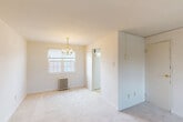 Located at 717 University Blvd E in Silver Spring, MD, this one-bedroom, one-bathroom unit offers a thoughtfully organized single-floor layout. The combined living and dining area is bright and open, featuring soft neutral carpet, crisp white walls, and an elegant chandelier. Natural light filters in through windows accented with classic radiator heating units, lending a timeless character to the space. An archway connects the living area to the rest of the unit, adding a subtle architectural detail.

The bedroom is a comfortable, well-proportioned retreat with plush carpeting, a window-mounted air conditioning unit, a radiator, and a bifold closet door providing convenient storage. In addition to the bedroom closet, the unit includes three closets in total, offering generous storage throughout.

The kitchen features rich, dark wood cabinetry paired with light granite-look countertops and a stainless steel sink. Light-toned flooring and a window bring brightness to the space. The bathroom maintains a classic aesthetic with white subway tile surrounding the tub/shower combination, accented by dark border tiles for a crisp, defined look.

A hallway connects the rooms efficiently, completing this well-organized and functional layout ideal for Silver Spring living.