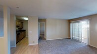 Located at 800 E Lexington in El Cajon, unit #221 is a single-floor residence offering a well-organized layout with distinct living, dining, and sleeping areas. The open living room features neutral-toned carpet, smooth walls, and a sliding glass door with vertical blinds that allows natural light to fill the space. Adjacent to the living area, a dedicated dining space is highlighted by an elegant multi-bulb chandelier and a pass-through window connecting to the kitchen.

The galley-style kitchen is well-appointed with light wood cabinetry, dark granite countertops, a double stainless steel sink, and hardwood-style flooring. Stainless steel appliances, including a refrigerator, microwave, and electric range, complete the functional setup. A spacious bedroom offers plush carpeting and a window with blinds that brings in natural light.

Two full bathrooms mirror each other in design, each featuring a tub-shower combination with tile surround, a granite-topped vanity with an vessel-style sink, a large mirror, and warm lighting. A convenient in-unit stacked washer and dryer is tucked neatly into a dedicated alcove, adding to the practicality of this well-designed residence.