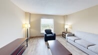 Located along Kingston Pike in Knoxville, TN, this 2-bedroom, 1-bathroom unit offers a functional and efficiently organized single-floor layout. The living room serves as the central gathering space, featuring light wood-style flooring, neutral beige walls, and a textured ceiling. A large window frames pleasant outdoor views, filling the room with natural light and creating an open, airy atmosphere.

Both bedrooms continue the light flooring and neutral color palette, each offering a comfortable and practical environment. The primary bedroom includes a built-in closet with louvered doors for ample storage, while windows in the bedrooms provide the same attractive outdoor views seen throughout the unit. Each room is well-proportioned for everyday living and study.

The bathroom features a full tub-shower combination enclosed by classic cream-toned tile with contrasting brown tile accents, lending a clean and timeless look. A connecting hallway links the rooms cohesively, contributing to the unit's straightforward and navigable floor plan.

Throughout the space, consistent flooring, soft neutral tones, and practical layouts create a cohesive, low-maintenance environment. The elevated positioning of the unit, reflected in the scenic treetop views visible from multiple windows, adds a notable highlight to this well-located Knoxville residence.
