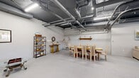 Located at 742 S Westlake Ave in Los Angeles, this single-floor open-plan space offers a generously sized, flexible interior well-suited for events, gatherings, or creative use. The layout is unified and open, allowing the entire footprint to flow seamlessly from one functional zone to the next.

The space is defined by its industrial-chic aesthetic. An exposed ceiling reveals a network of painted ductwork, conduit, and structural elements overhead, while linear fluorescent and LED fixtures provide consistent, bright illumination throughout. The polished concrete floors lend a clean, durable finish that complements the raw architectural details above.

White-painted walls serve as a neutral backdrop, keeping the interior bright and adaptable. The space is currently arranged into distinct functional areas: a dining zone featuring a large wooden table surrounded by high-backed upholstered chairs, a lounge area outfitted with plush sofas, glass-topped coffee tables, and decorative shelving units displaying curated accessories, and an additional seating vignette with accent chairs and open shelving. Subtle decorative touches — wall art, sculptural pieces, and greenery — add warmth and character without overwhelming the open layout.

A utility area with a service station and restroom access is discreetly positioned near the entrance. The space is accessed via a secure door and is well-suited to a variety of programming needs.