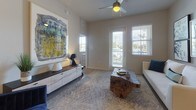 This single-floor residence offers a thoughtfully designed layout with a contemporary aesthetic carried consistently across every room. Light wood-style flooring flows throughout the unit, complementing neutral wall tones that create a bright, cohesive interior.

The kitchen is a standout feature, equipped with dark espresso cabinetry extending to the ceiling for generous storage, a mosaic tile backsplash, white quartz-style countertops, and a full suite of stainless steel appliances including a side-by-side refrigerator, electric range, and over-the-range microwave.

The living area benefits from multiple windows and a glass-panel door that invite abundant natural light, while a ceiling fan adds functional comfort. The space comfortably accommodates a full seating arrangement.

Two well-proportioned bedrooms each feature natural light from sizable windows. The primary bedroom includes a softly lit, serene ambiance, while the second bedroom offers outdoor views and ample floor space.

Two bathrooms serve the residence: one features a tiled tub-shower combination with a framed vanity mirror and dark cabinetry, while the second offers a glass-enclosed walk-in shower with clean tile surround and matching finishes.

A dedicated in-unit laundry area with full-size washer and dryer adds everyday convenience.