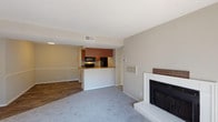 Located at 6713 Six Forks Rd in Raleigh, NC, this single-floor residence offers a well-organized layout with a comfortable, functional design throughout. The living area is a welcoming focal point, highlighted by a classic white-framed fireplace and plush carpeting that creates a warm, relaxed atmosphere. The space opens naturally toward a dining area, both connected to the kitchen via a convenient peninsula counter with a breakfast bar overhang — ideal for casual dining or entertaining.

The kitchen is thoughtfully designed with warm wood-toned cabinetry, granite-style countertops, black appliances including a refrigerator, stove, and microwave, and hardwood-style flooring that extends through the dining and entry areas. A pantry closet adds practical storage within the kitchen corridor.

The bedrooms are generously sized, featuring soft carpeting, neutral wall tones, and windows with blinds that allow for natural light while maintaining privacy. The spacious layout of the primary bedroom accommodates a variety of furniture arrangements.

Two full bathrooms mirror each other in style, each featuring rich wood-toned vanities with granite-style countertops, a tub-shower combination, and hardwood-style flooring. The overall aesthetic throughout the home is clean and neutral, offering a versatile backdrop well-suited to a range of personal styles.