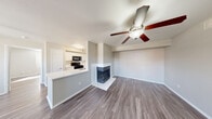 Located at 6250 Granbury Cut Off St in Fort Worth, TX, this single-story 2-bedroom, 2-bathroom home offers a well-organized layout with a clean, modern aesthetic throughout. Wood-look plank flooring runs continuously across the main living areas, lending a cohesive and contemporary feel. The open-concept living and dining area is anchored by a distinctive corner fireplace and outfitted with a ceiling fan, creating a comfortable and functional gathering space. Sliding glass doors connect the living area to a private patio, bringing in natural light and easy outdoor access. The kitchen features white cabinetry, a white quartz peninsula with a built-in sink, stainless steel refrigerator and dishwasher, and black appliances including a range and over-the-range microwave. A pantry provides additional storage, and dedicated laundry space adds everyday convenience. Both bedrooms are well-proportioned, each with a ceiling fan, wood-look flooring, and natural light from windows. The primary bedroom includes its own closet. The two bathrooms are finished with white vanities, tub-shower combinations with tiled surrounds, and wood-look flooring. Six closets throughout the home ensure ample storage. Neutral gray and white tones give the entire space a clean, move-in-ready appearance.