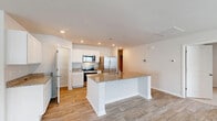 Located at 4118 Hobblebush Dr in Leland, NC, this single-story, 3-bedroom, 2-bathroom home offers a well-designed, functional layout across a comfortable footprint. The open-concept living area seamlessly connects the living room, dining room, and kitchen, creating an inviting space for everyday living and entertaining. The kitchen is appointed with white cabinetry, granite countertops, stainless steel appliances including a range, microwave, refrigerator, and dishwasher, and a central island with a sink — all set atop durable wood-look flooring. The entry foyer features a vaulted ceiling accent and multiple windows that bring in natural light. The generously sized primary bedroom includes a ceiling fan, plush carpeting, and natural light from large windows, and is complemented by a spacious walk-in closet with wire shelving. Two additional carpeted bedrooms also feature windows with neighborhood views. Both bathrooms include tub/shower combos with built-in shelving. A dedicated laundry room houses a full-size washer and dryer with overhead wire shelving. A pantry adds convenient storage. The attached garage offers ample space with a drywall interior, recessed lighting, and an automatic opener.