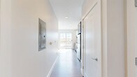 Located at 104 Washington St in Dover, NH, this thoughtfully designed one-bedroom, one-bathroom unit offers a clean, contemporary aesthetic throughout. Light-toned luxury vinyl plank flooring extends seamlessly across the entire space, complementing the crisp white walls and bright recessed lighting that create a fresh, modern atmosphere.

The open-concept kitchen and living area serves as the heart of the unit. The kitchen is outfitted with a full suite of stainless steel appliances, including a refrigerator, range, microwave, and dishwasher. Two-toned cabinetry — white uppers paired with slate-blue lowers — is accented by a subtle tile backsplash, offering both style and functionality. A large sliding glass door floods the living area with abundant natural light and provides views of the surrounding neighborhood.

A hallway connects the main living area to the private bedroom and bathroom. The bedroom is a cozy, well-proportioned retreat with warm-toned flooring and a ceiling fan. The bathroom features a walk-in shower with a framed glass door, a single-sink vanity with white cabinetry, built-in shelving, and clean finishes throughout. The unit's efficient layout maximizes every square foot, making it an ideal space for comfortable, modern living in the heart of Dover.