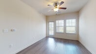 This single-floor residence offers a clean, modern layout designed for comfortable everyday living. The main living area makes a strong first impression with its warm hardwood-style flooring, neutral cream walls, and a ceiling fan with integrated lighting. A glass door and dual windows allow ample natural light to fill the room, creating a bright and airy atmosphere throughout. Adjacent to the living space, the entryway provides a smooth transition into the home, with hardwood-style flooring continuing toward the kitchen.

The galley-style kitchen is a functional highlight, featuring rich dark cabinetry, granite countertops, a double-basin sink, and a full suite of black stainless appliances including a refrigerator, range, microwave, and dishwasher. Recessed lighting overhead ensures the kitchen is well-lit for meal preparation.

The bedrooms are finished with plush neutral carpet, providing a comfortable and quiet retreat. Two bathrooms serve the home: one full bathroom featuring tile-surround tub and shower combo with dark cabinetry and wood-look flooring, and a second bathroom with a single vanity, large mirror, and matching finishes throughout. Together, the spaces offer a cohesive, move-in-ready environment with practical design choices at every turn.