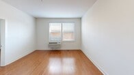 Located at 103 S Wood Ave in Linden, NJ, this one-bedroom, one-bathroom unit offers a thoughtfully designed layout making excellent use of its single-floor footprint. Warm hardwood flooring flows consistently throughout the living and bedroom areas, lending a cohesive and inviting character to the space.

The kitchen is a standout feature, equipped with rich dark espresso cabinetry, granite countertops, and a suite of black appliances including a range, microwave, dishwasher, and refrigerator. A peninsula with an undermount sink and extended counter space opens toward the living area, creating a connected, open-concept feel ideal for everyday living.

The bedroom is a well-proportioned, sun-lit retreat featuring a window with blinds, a wall-mounted HVAC unit, and clean white walls that maximize the sense of openness. Natural light enters comfortably, enhancing the room's airy ambiance.

The bathroom continues the consistent design language of the unit, featuring light wood-look tile flooring, a dark vanity with storage cabinetry above, and clean white walls. Grab bars provide added accessibility, and the layout is efficient and practical.

Overall, the unit presents a clean, modern aesthetic with consistent finishes throughout, offering comfortable, functional living in Linden, NJ.