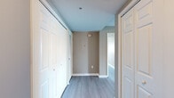Located at 555 Church St in the heart of Nashville, TN, this 2-bedroom, 2-bathroom residence offers a well-designed single-floor layout that maximizes both comfort and functionality. Light wood-style flooring flows consistently throughout, complemented by neutral taupe and gray walls that create a clean, cohesive aesthetic.

The combined kitchen and living area serves as the central hub of the unit. The kitchen is outfitted with dark espresso cabinetry, granite countertops, stainless steel appliances including a refrigerator, range, and built-in microwave, and track lighting overhead. The adjacent living room features a wall of windows fitted with horizontal blinds, framing sweeping views of the Nashville downtown skyline and filling the space with abundant natural light.

The primary bedroom is a well-proportioned retreat with a sliding glass door opening to a private balcony, offering elevated city views. A closet with sliding panel doors provides ample storage. The second bedroom also enjoys natural light through a window overlooking the cityscape and includes its own closet with bifold doors.

Both bathrooms share a consistent design language, featuring granite-topped dark vanities, undermount sinks with chrome fixtures, and tub-shower combinations with curved curtain rods. A central hallway connects the bedrooms and bathrooms, lined with additional closet storage for added convenience.