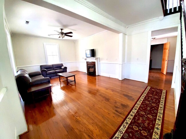 Hermosa sala amplia con pisos de madera de roble y amueblada con muebles de calidad y Smart TV. - 526 Monroe St