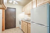 Located at 2120 University Ave in Madison, Wisconsin, this one-bedroom, one-bathroom unit offers an efficiently organized single-floor layout. The space makes smart use of every square foot across its two main areas.

The kitchen is positioned at the entry and features light maple cabinetry — both upper and lower — laminate countertops, a stainless steel sink, an electric coil range, and a full-size refrigerator. Tile flooring runs throughout the kitchen area, providing a clean, easy-to-maintain surface.

The bedroom is the largest room in the unit, offering generous proportions with wall-to-wall carpeting for comfort. A large window allows natural light to fill the room and provides a pleasant view of the surrounding greenery. A wall-mounted air conditioning unit and baseboard heating ensure year-round climate control. A sliding-door closet with built-in shelving and hanging rods offers practical storage.

The bathroom is accessed conveniently from the main living area and includes a light maple vanity with an integrated sink, a lighted mirror, a toilet, and tile flooring, maintaining a consistent design aesthetic throughout the unit.

A ceiling fan serves the main living area, and the textured ceiling adds a classic touch to the overall interior. This unit is ideally situated near the University of Wisconsin–Madison campus.