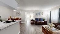 Located at 962 W Second St in Rialto, California, this single-story, three-bedroom home offers a well-designed layout that balances comfort and functionality. The open-concept living and dining area features wood-look flooring, neutral-toned walls, and large windows dressed with elegant drapes that fill the space with natural light. A textured ceiling adds character throughout the main living areas.

The kitchen is a standout feature, showcasing crisp white cabinetry, granite-style countertops, a peninsula with bar seating, and a full suite of stainless steel appliances. A window above the sink provides natural light, making the kitchen both practical and inviting. The adjacent dining area offers an intimate setting, complemented by the same warm flooring and soft neutral palette.

The expansive primary bedroom is a true retreat, featuring plush carpeting, a sliding glass door with outdoor views, and a dedicated walk-in closet offering generous storage. Two additional bedrooms provide flexibility for various living needs. A hallway connects the bedrooms efficiently to the main living spaces.

A large walk-in closet serves as a dedicated storage area, while the overall floor plan ensures a smooth, connected flow between all rooms. The landscaped exterior, visible in the point cloud scan, adds to the home's curb appeal in this Rialto neighborhood.