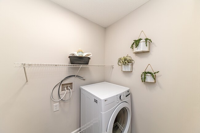 Laundry room with built in shelving - The Alexander Apartment Homes