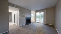 Located at 8335 Hyannis Port Dr in Dayton, Ohio, this one-bedroom, one-bathroom residence offers a thoughtfully designed single-floor layout. The living room serves as the centerpiece of the home, featuring a tile-surround wood-burning fireplace with a crisp white mantel and plush carpeting underfoot. Sliding glass doors flood the space with natural light and open directly onto a private balcony with outdoor views, seamlessly connecting the living and dining areas to the outdoors. The galley-style kitchen is well-equipped with white cabinetry, granite countertops, a stainless steel sink, and black appliances, with light wood-look flooring adding a clean, modern touch. A dedicated laundry room houses a full-size washer and dryer on durable vinyl plank flooring, adding everyday convenience. The carpeted bedroom offers a comfortable retreat with a large window that brings in natural light and scenic outdoor views, complemented by a spacious closet. The bathroom features a full soaking tub and shower enclosed in classic white subway tile. Neutral gray tones throughout the home create a cohesive, move-in-ready ambiance ideal for comfortable living.