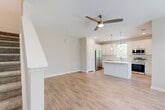 Located at 1387 East Vine Street in Kissimmee, Florida, this two-story, three-bedroom, three-bathroom home offers a thoughtfully designed layout spread across two balanced floors. The main level features an open-concept living room and kitchen, unified by warm wood-look flooring and neutral tones throughout. The kitchen is a standout, boasting white shaker cabinetry, a central island with pendant lighting, stainless steel appliances including a refrigerator, dishwasher, microwave, and range, plus a window above the sink that brings in natural light. The living area is complemented by a ceiling fan and a staircase leading to the upper level. Upstairs, the three bedrooms offer comfortable proportions, with carpeted floors and windows providing natural light and exterior views. The spacious primary bedroom includes its own dedicated closet with wire shelving systems for organized storage. Each of the three bathrooms is finished with marble-look tile flooring, white vanities with modern fixtures, and tiled shower enclosures. A hallway and three closets contribute to the home's practical storage capacity. The clean, modern aesthetic with light walls and contemporary finishes gives the entire space a bright, move-in-ready feel.