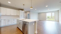 Located at 4455 Winder Dr in Dublin, OH, this thoughtfully designed single-floor residence offers three bedrooms, two bathrooms, and a dedicated closet across a well-appointed layout. The open-concept kitchen and living area serves as the heart of the home, anchored by a large center island with bright white quartz countertops, white shaker-style cabinetry, a classic tile backsplash, and a full suite of stainless steel appliances including a refrigerator, range, microwave, and dishwasher. Warm-toned hardwood-style flooring flows throughout the main living areas, complemented by recessed lighting and stylish pendant fixtures above the island. The living room is filled with natural light from large windows and features a door leading to a private outdoor balcony with open views of the surrounding area. The spacious primary bedroom includes plush carpeting and generous windows, while the en-suite bathroom offers a dual-sink vanity with white cabinetry, brushed nickel hardware, and a walk-in glass-door shower. Additional bedrooms are carpeted with ample natural light. The second bathroom features a clean, modern design with a single vanity and glass-enclosed shower. A dedicated walk-in closet adds practical storage to complete this well-organized residence.