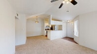 Located in Palm Bay, Florida, this one-bedroom, one-bathroom residence offers a well-designed single-floor layout with a comfortable and functional flow throughout. The living room is a standout space, featuring vaulted ceilings, a ceiling fan with light fixture, and expansive sliding glass doors that flood the room with natural light and open to a private outdoor patio with views of the surrounding greenery. Neutral carpet and a textured ceiling complete the airy feel of this central gathering area. The kitchen is thoughtfully laid out in a galley style with white cabinetry, laminate countertops, wood-look flooring, track lighting, and black and stainless steel appliances including a range, refrigerator, and dishwasher. A curved breakfast bar connects the kitchen to the living area, adding both functionality and an open feel. The bedroom offers a comfortable retreat with soft carpet, a window for natural light, a ceiling fan, and direct access to a dedicated closet. The full bathroom features a tub-shower combo with tile surround, wood-look flooring, a wide vanity mirror, and a countertop with ample workspace. A hallway connects the primary spaces, enhancing the efficient and cohesive layout of this well-appointed residence.